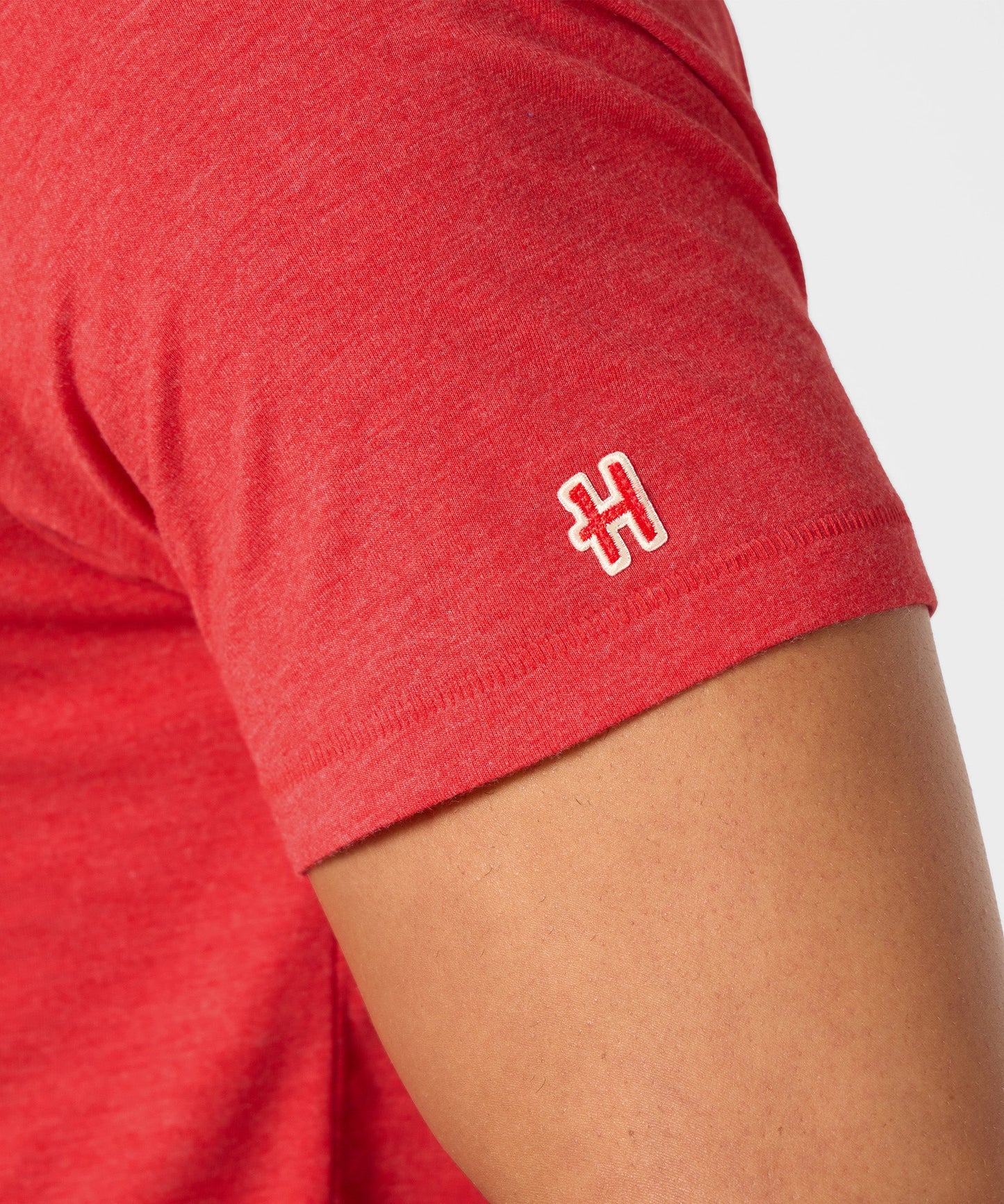 Lifestyle shot of the red t-shirt folded neatly on a wooden surface