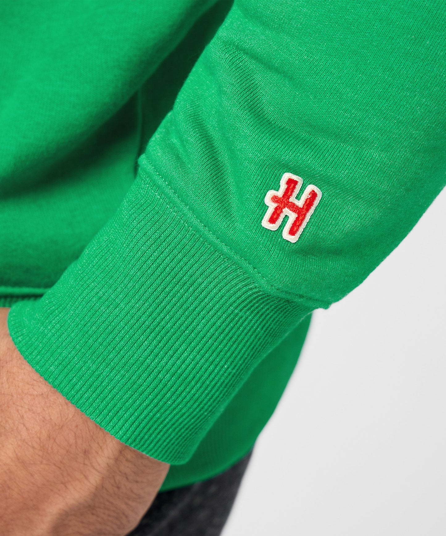 Folded green crewneck sweatshirt showing the classic Peanuts design