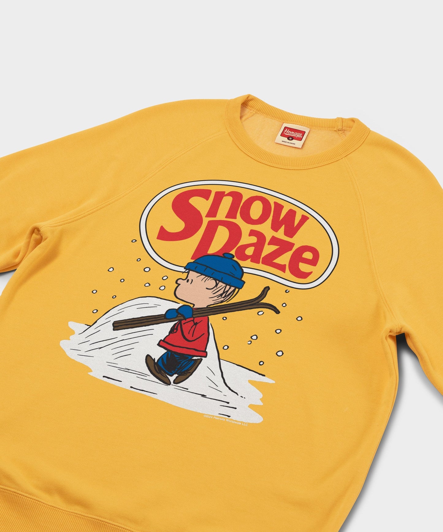 Close-up of the graphic print showing Linus and falling snowflakes on the gold fabric