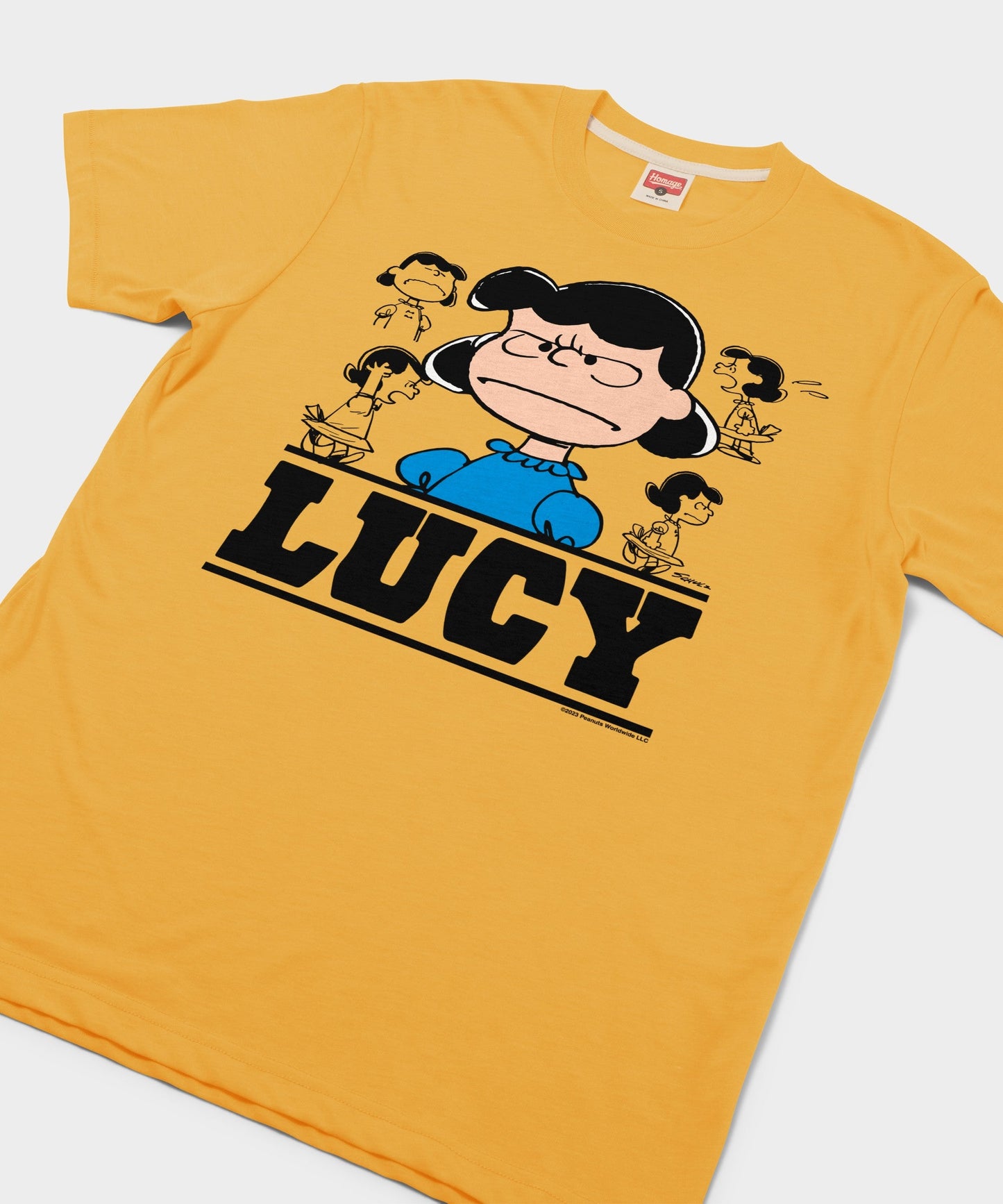 Close-up of the front screen-printed Lucy graphic showing her spirited expression on gold fabric