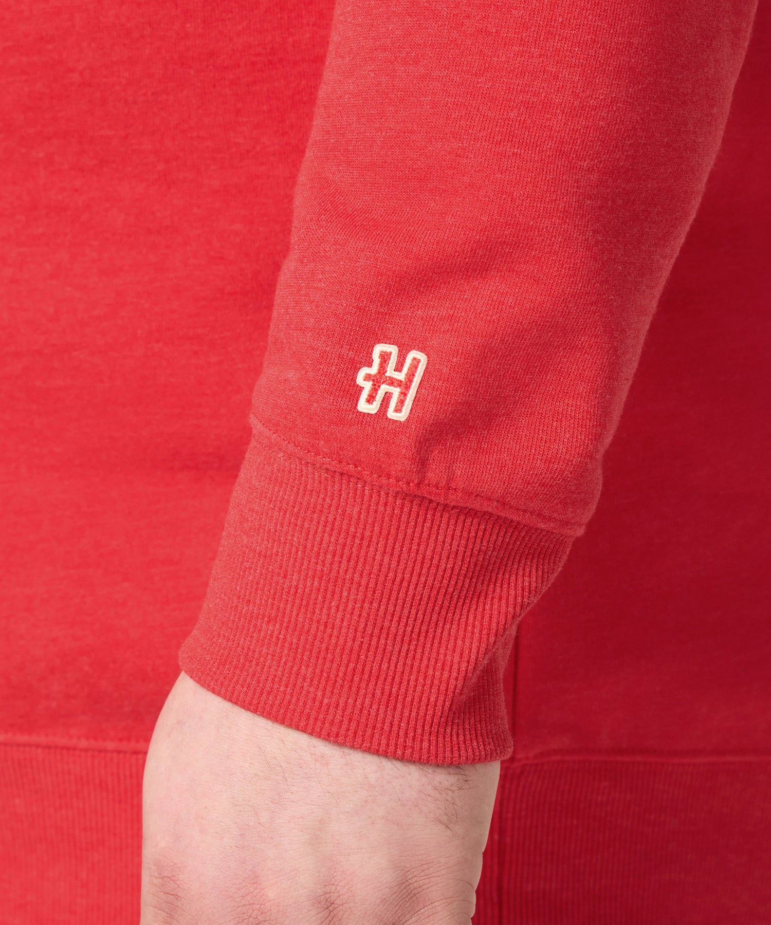 Folded red Peanuts crewneck sweatshirt showing the HOMAGE collaboration tag