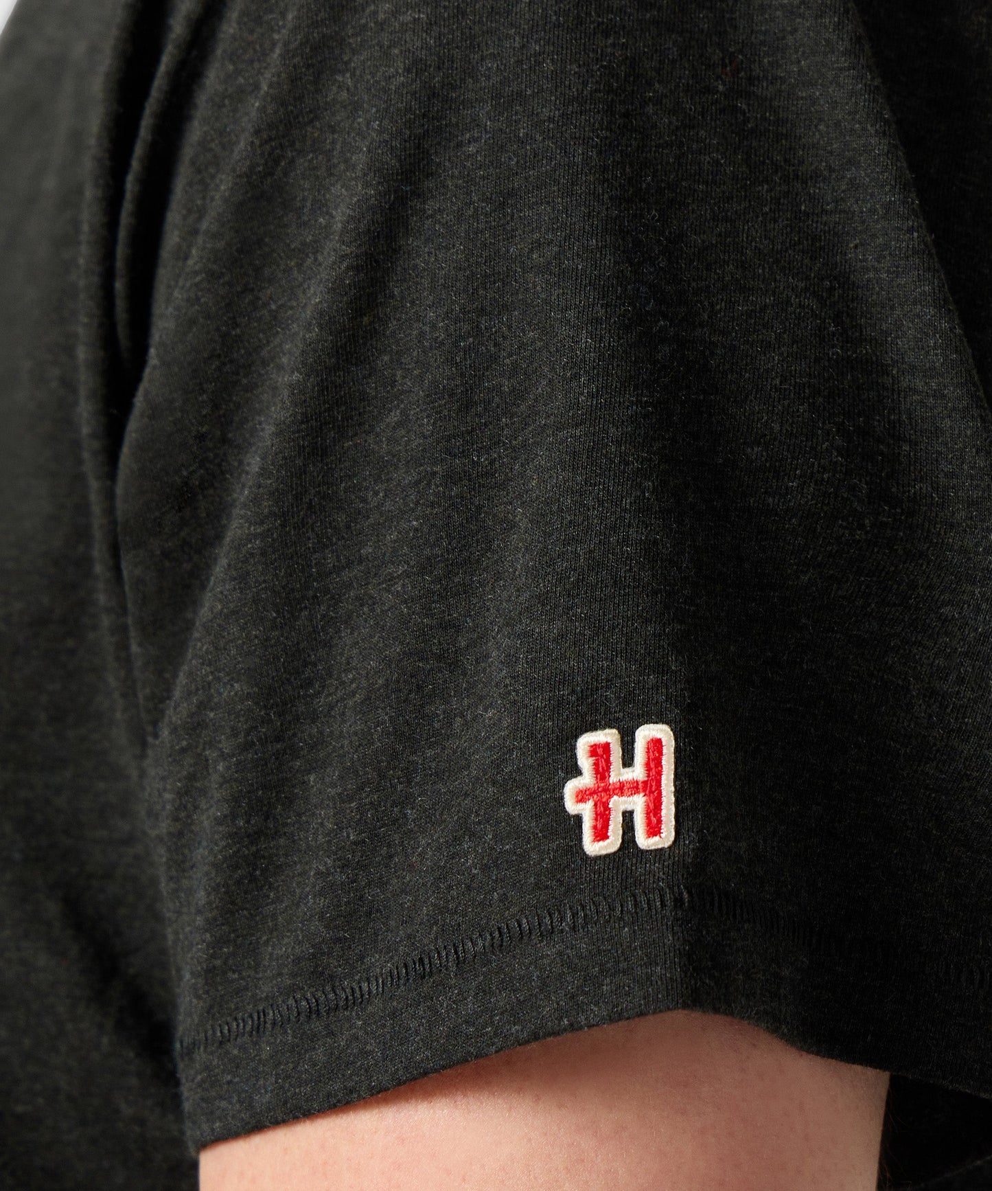 Folded view of the charcoal Peanuts t-shirt showcasing the official brand label