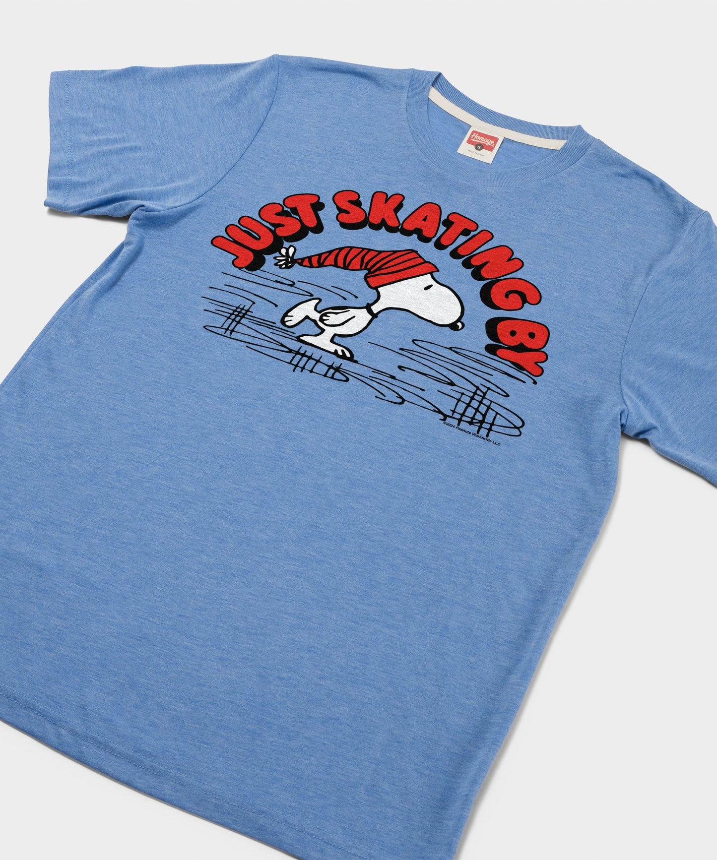 Close-up of the Snoopy ice skating graphic printed on the light blue t-shirt