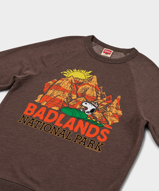 Brown crewneck sweatshirt featuring Snoopy resting in Badlands National Park on the front chest-1