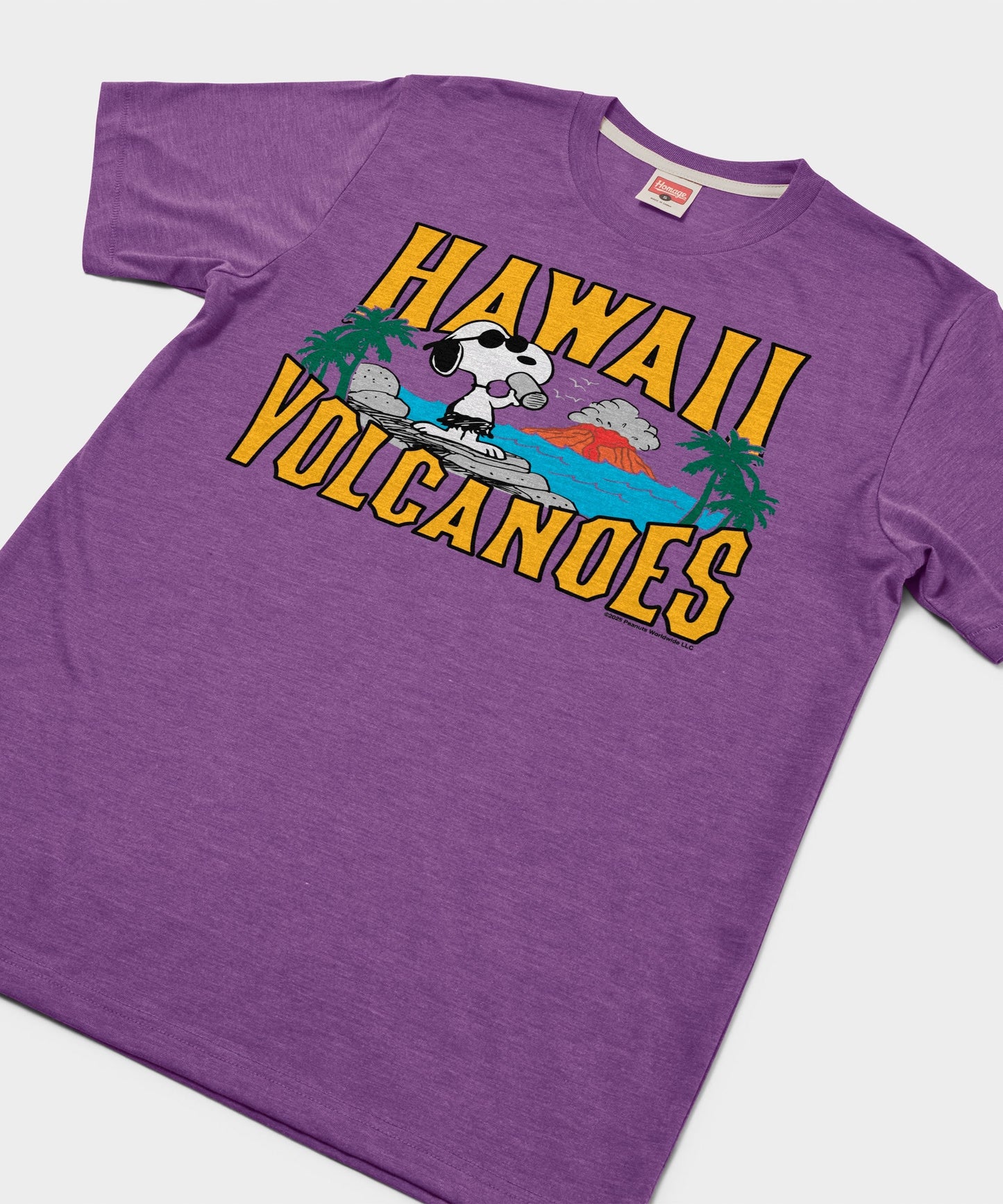 Close-up view of the Snoopy Hawaii Volcanoes graphic print on the royal purple fabric