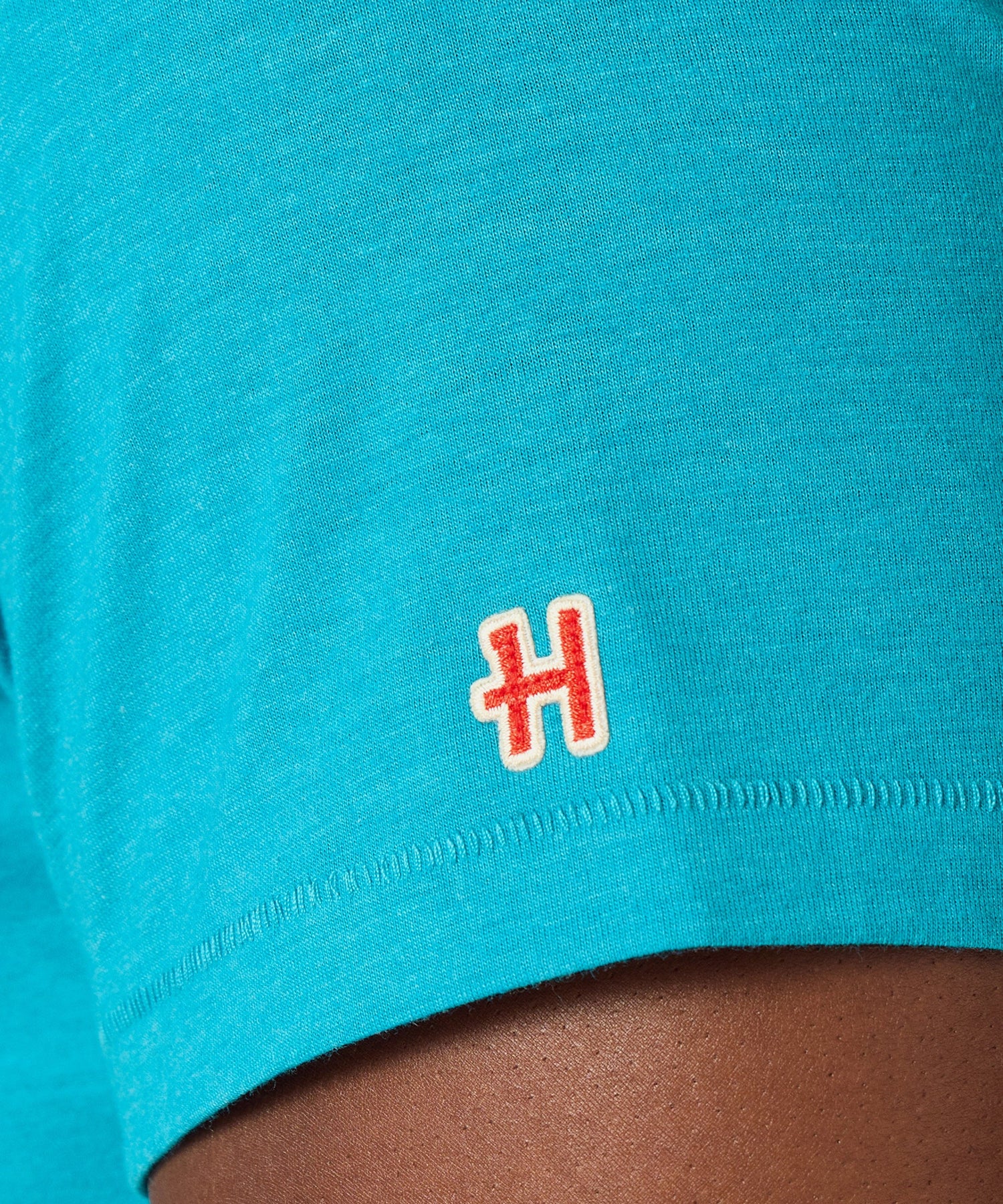 Fabric texture detail showing the soft cotton blend material in teal