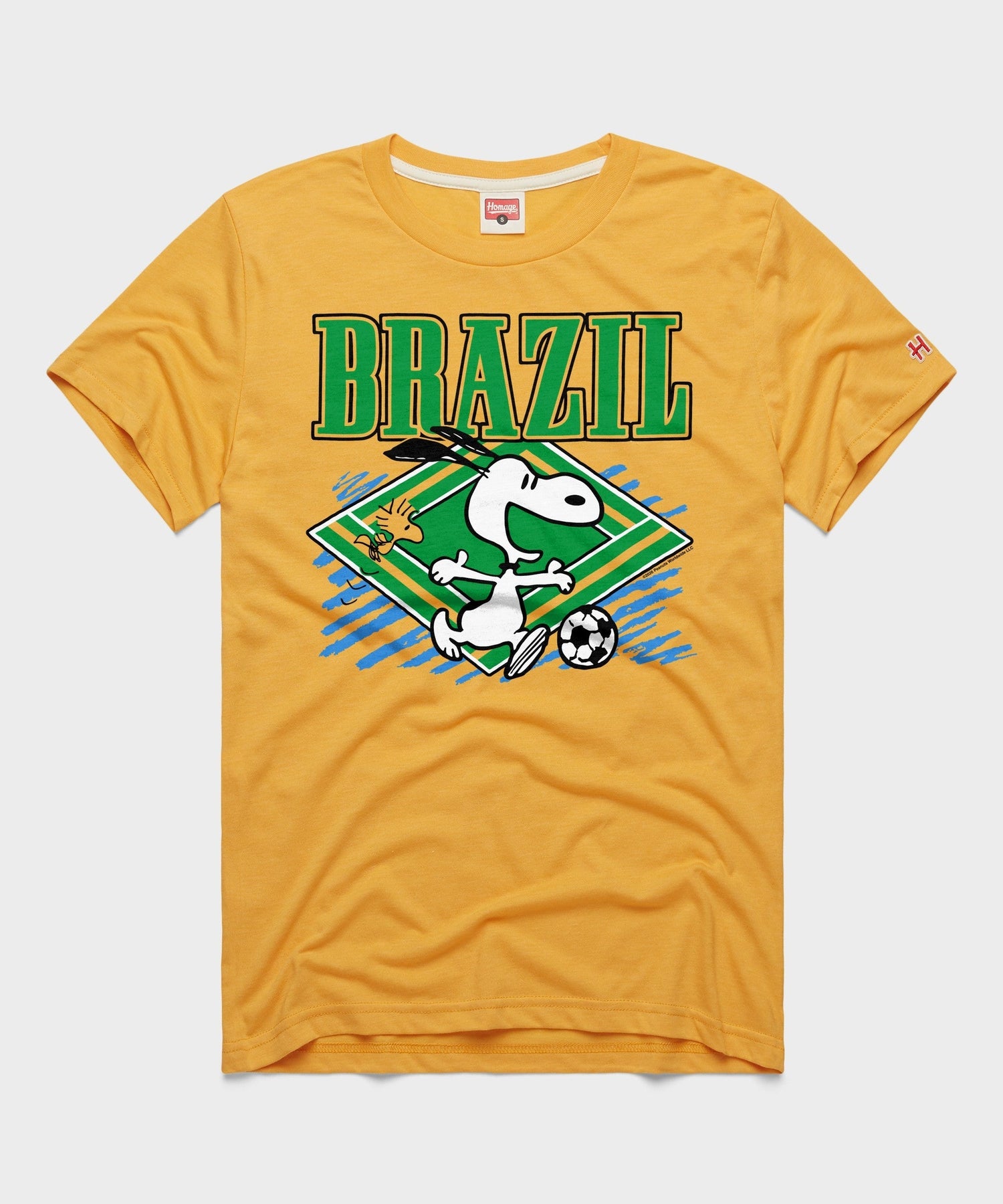 Gold tri-blend t-shirt featuring Snoopy playing soccer in Brazil team colors centered on the front
