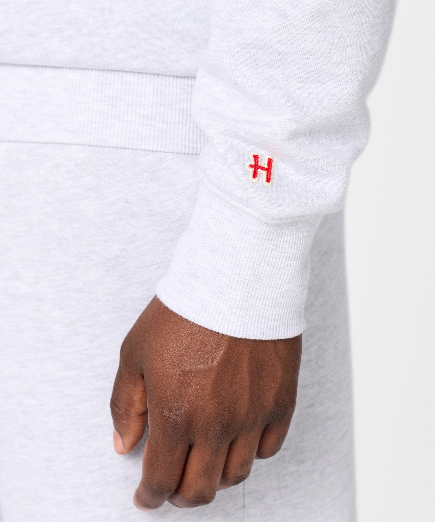 Folded ash grey crewneck sweatshirt neatly stacked on a surface