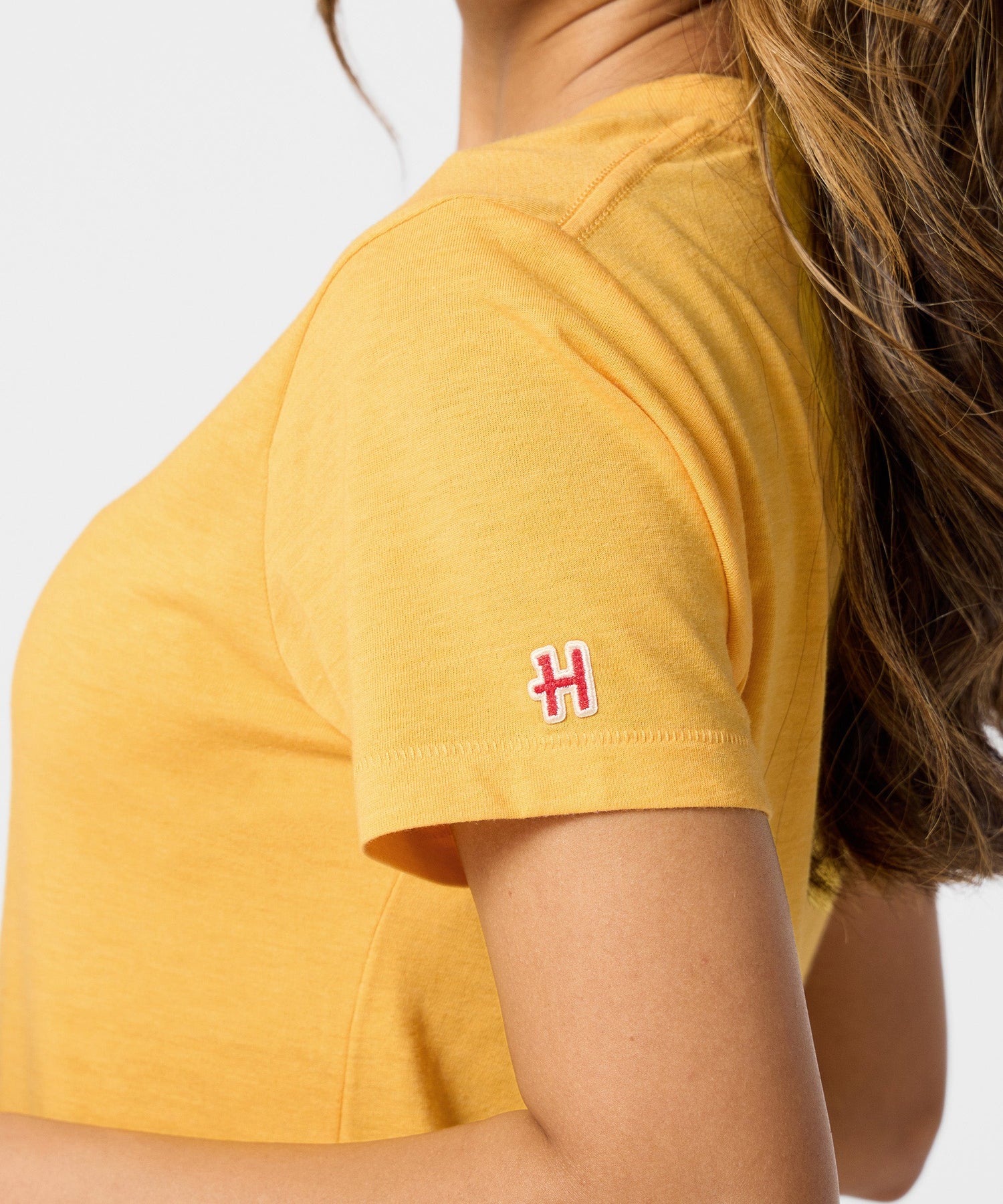 Folded gold t-shirt displayed flat