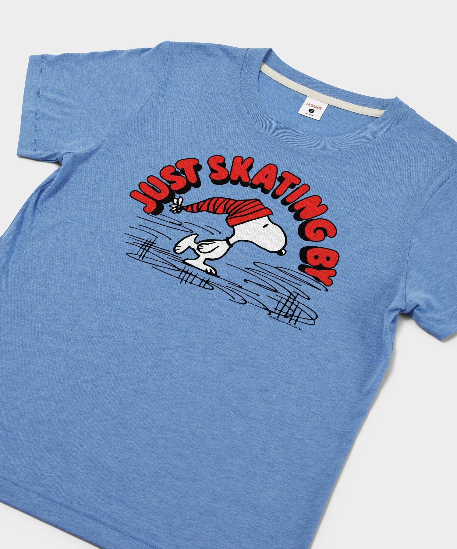 Close-up of the Snoopy ice skating graphic printed on the light blue t-shirt
