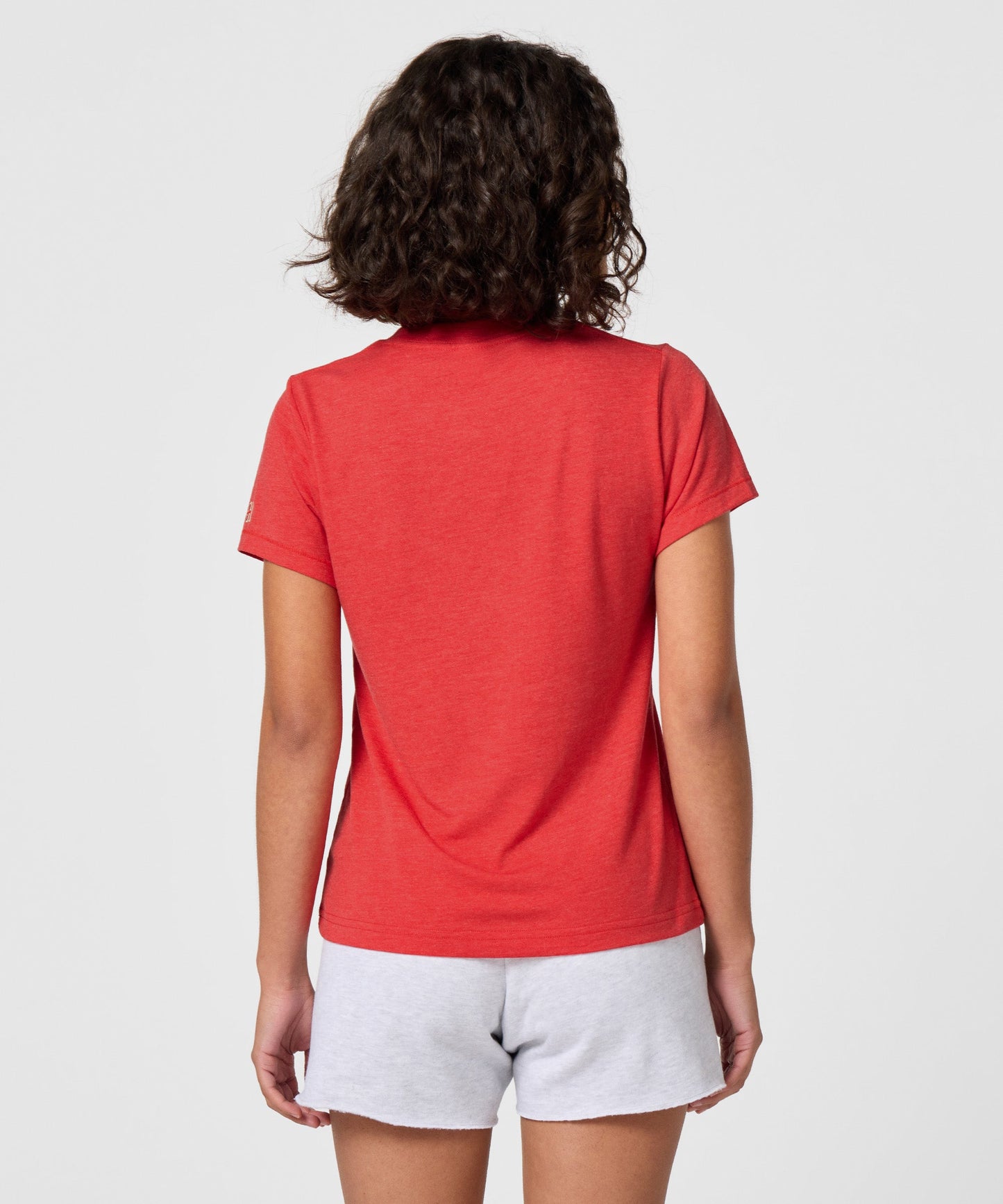 Detail shot of the HOMAGE collar tag and soft fabric texture inside the red t-shirt