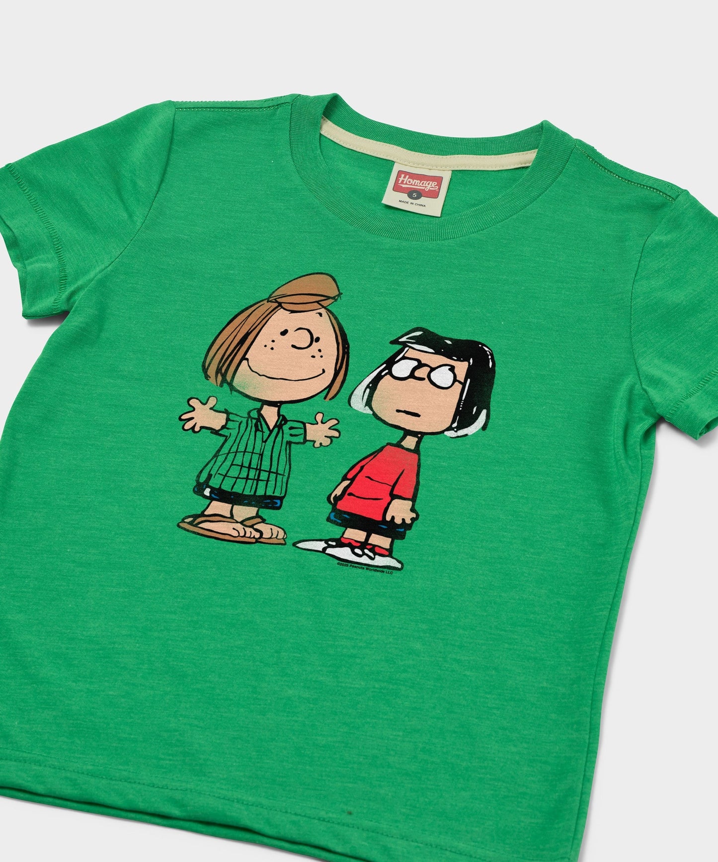 Close-up of the Peppermint Patty and Marcie graphic print on the front of the green youth t-shirt