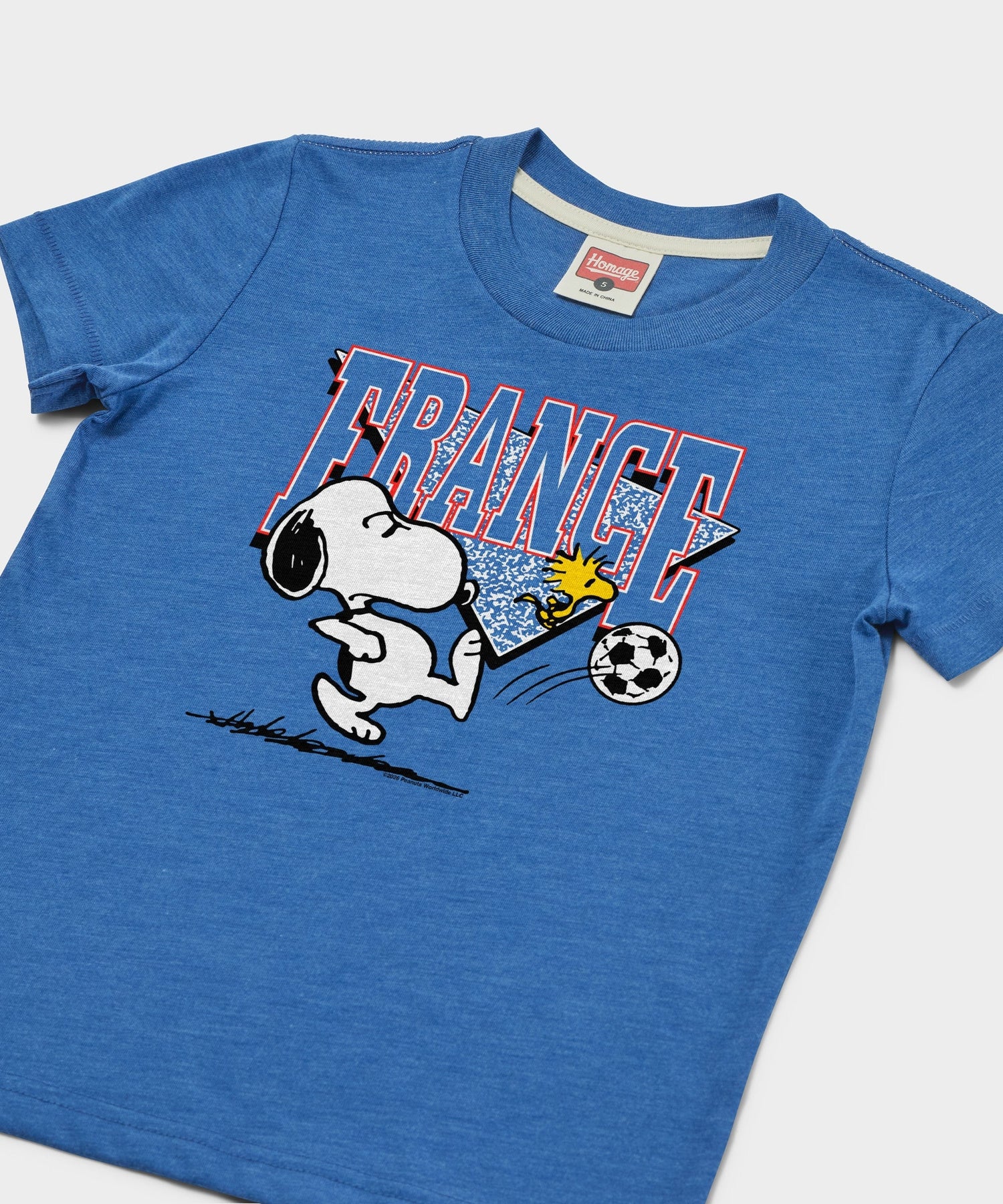 Close-up of the Snoopy soccer graphic printed on the chest of the youth t-shirt