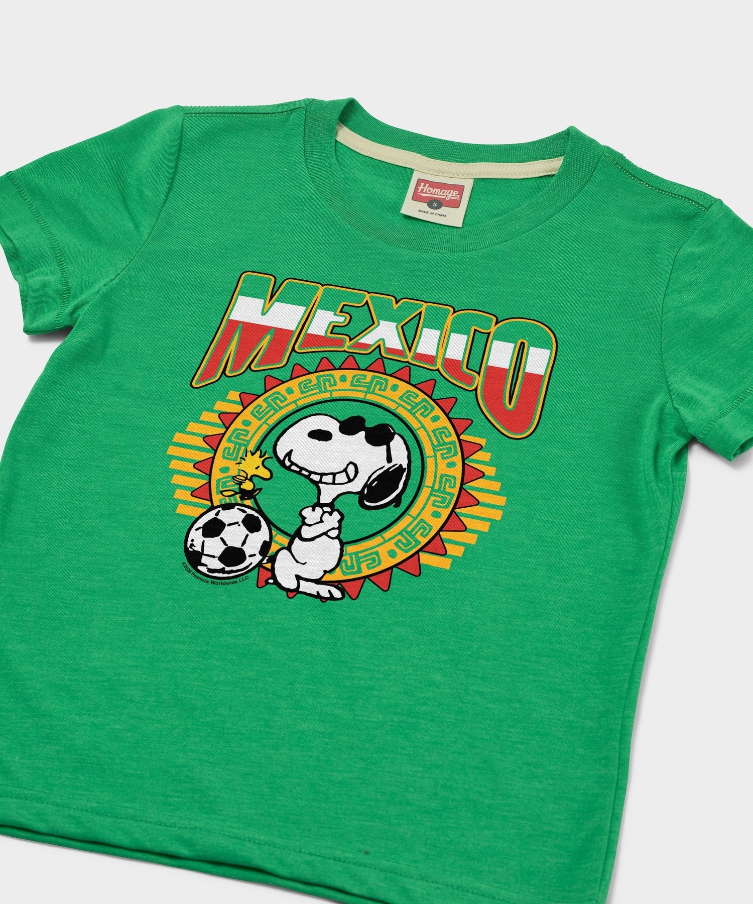 Close-up of the Snoopy soccer graphic printed on the green cotton t-shirt
