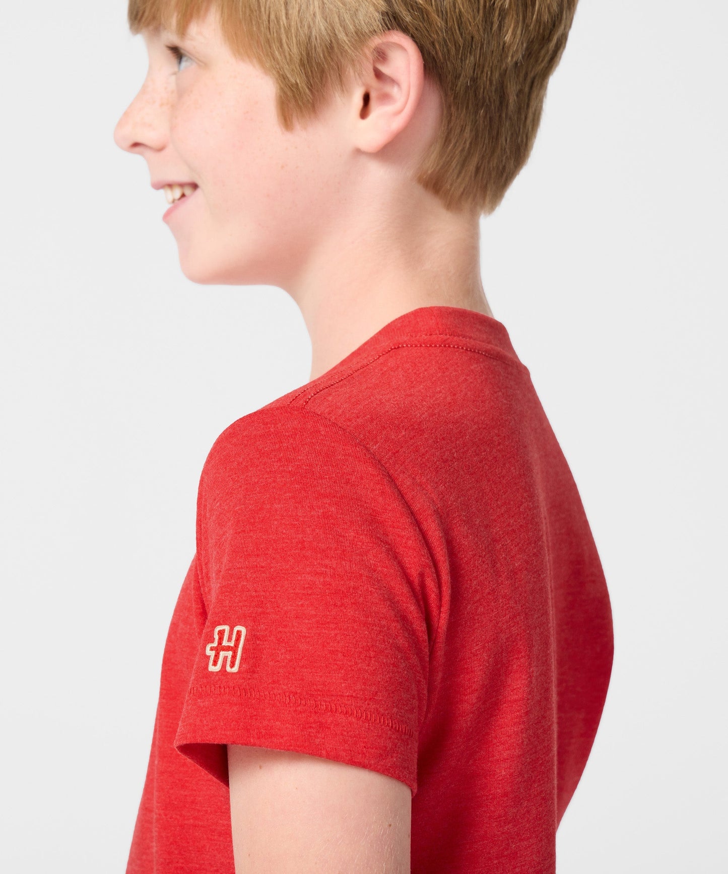 Lifestyle shot of a young fan wearing the red Snoopy Spain soccer t-shirt outdoors