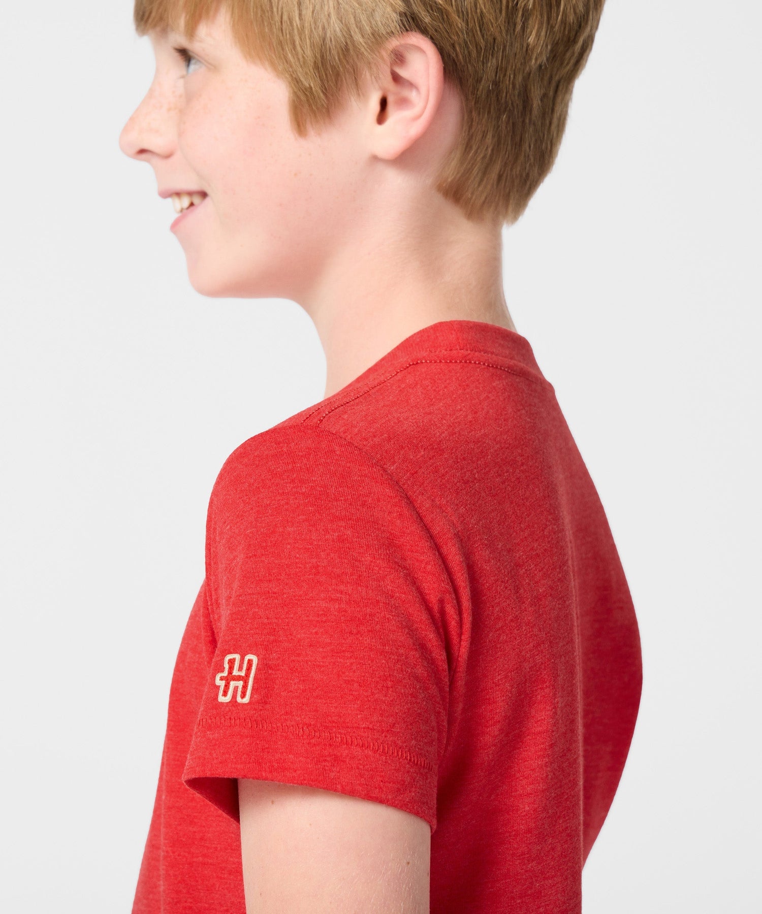 Lifestyle shot of a young fan wearing the red Snoopy Spain soccer t-shirt outdoors