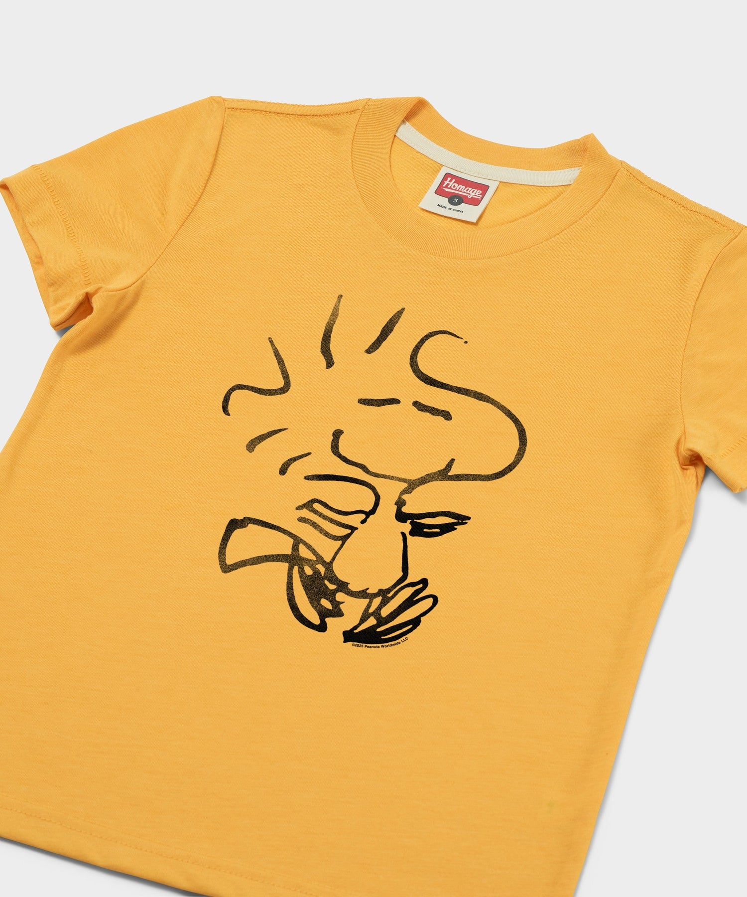 Close-up of the Woodstock graphic centered on the gold fabric