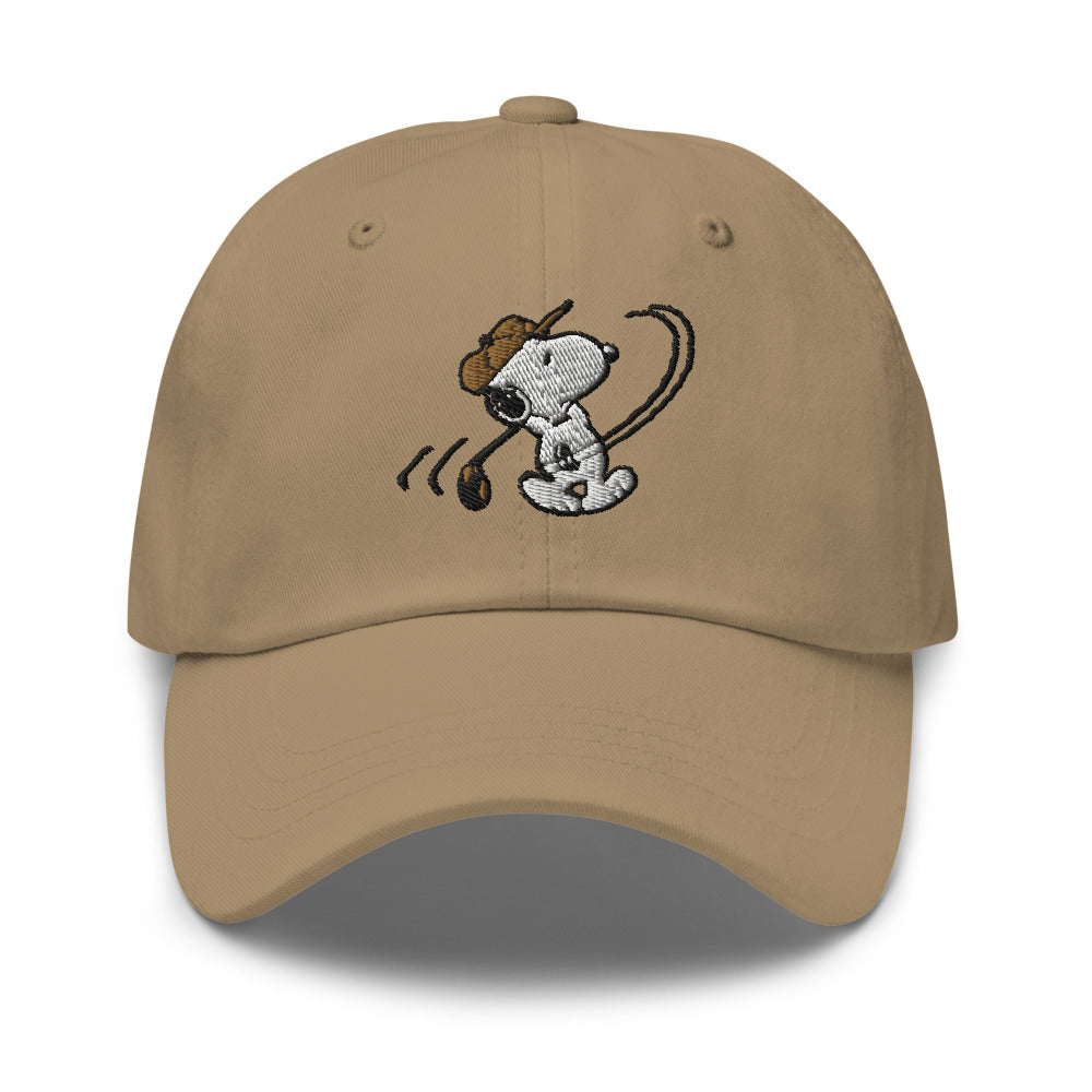 Khaki low-profile cotton baseball cap featuring an embroidered graphic of Snoopy ready to swing a golf club on the front panel