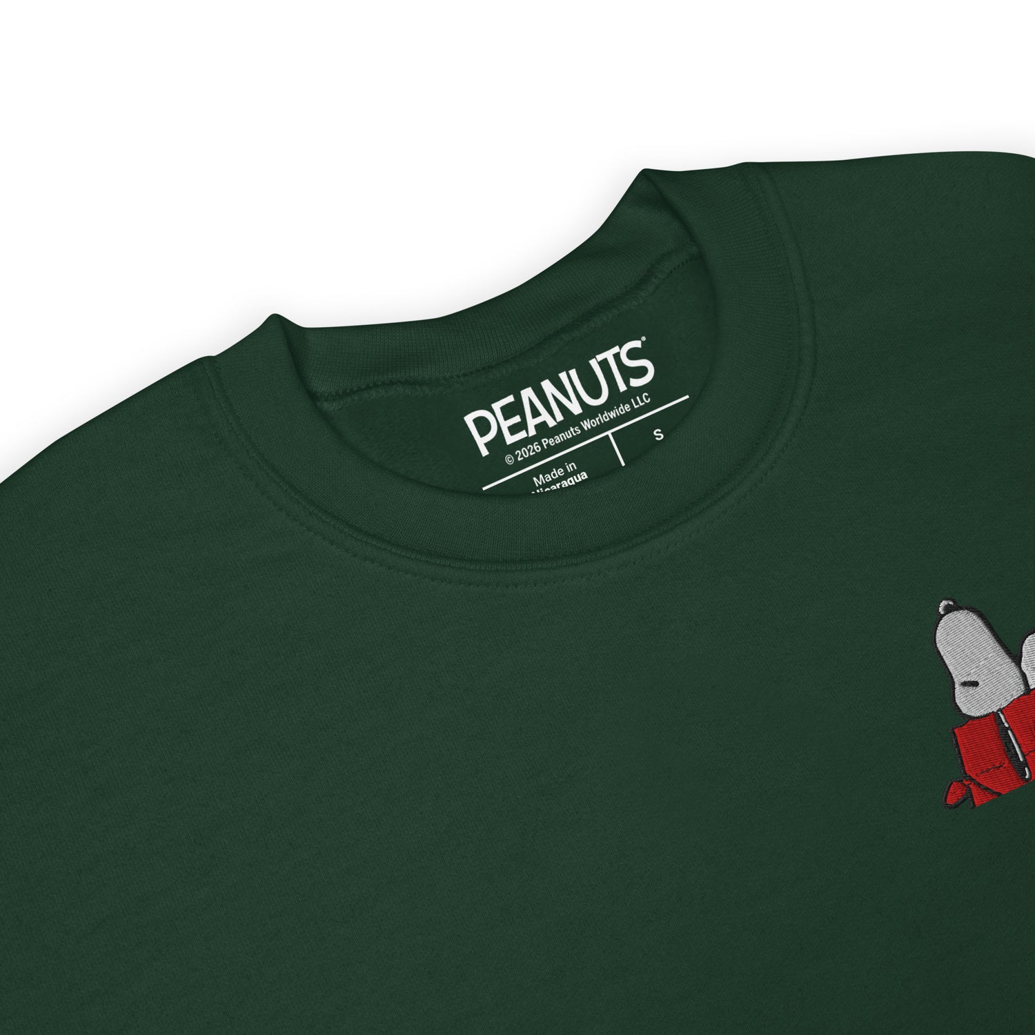 Close-up view of the Snoopy graphic printed on the forest green sweatshirt
